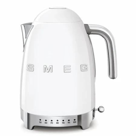 Biały czajnik elektryczny Smeg w stylu retro z lat 50., z chromowanymi detalami i wbudowaną w podstawę regulacją temperatury wody.